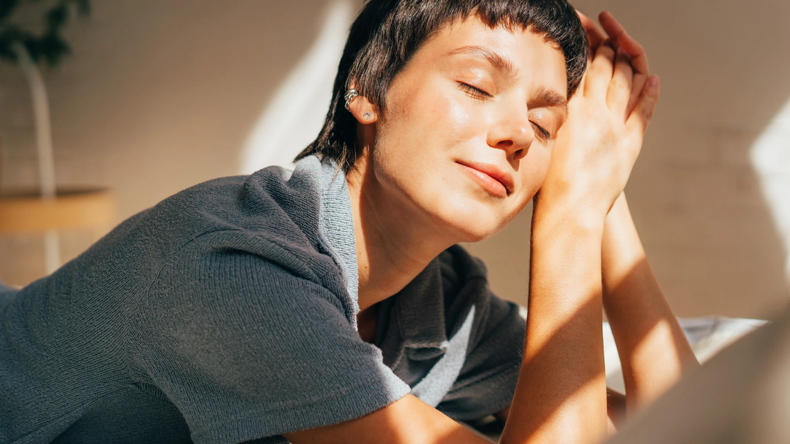 Schwarzhaarige Frau blickt in die Sonne und hat einen leicht gebräunten Teint | © AdobeStock/ Ilona